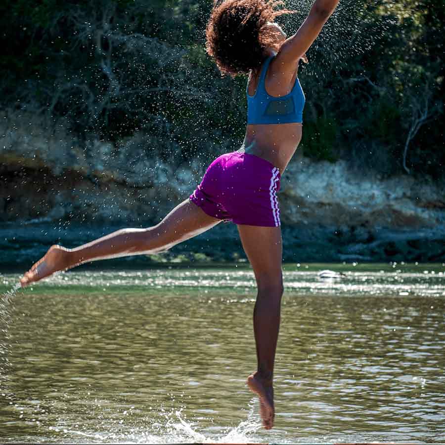 Adolescente en pleine forme sautant dans l'eau ostéopathe nyon